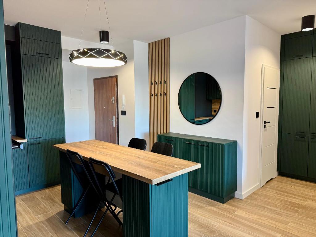 a kitchen with green cabinets and a wooden table at Drahan Apartment 28 in Radom