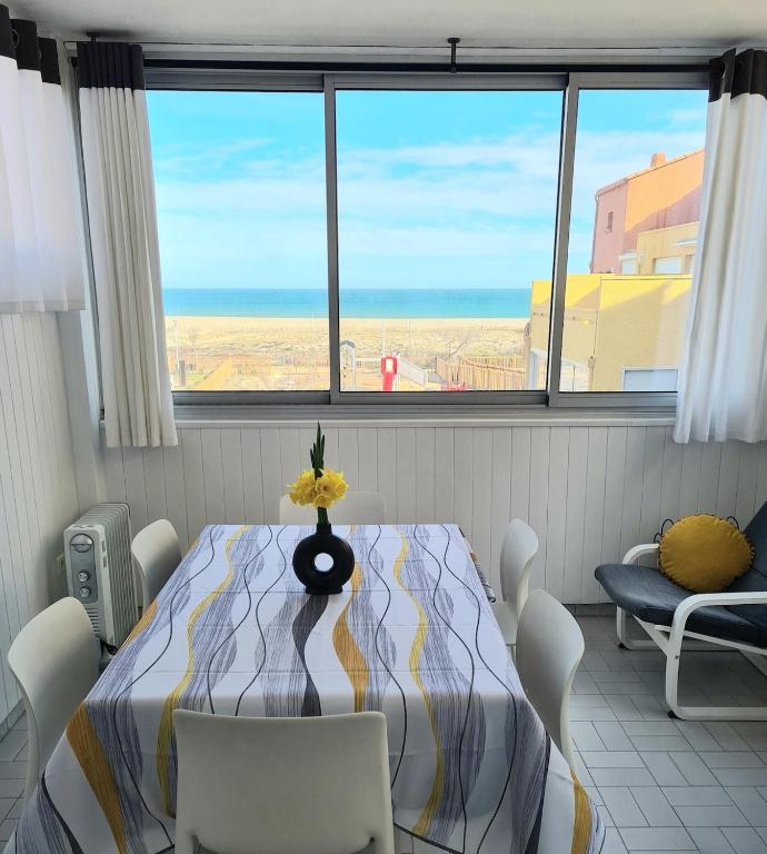 une salle à manger avec une table et une vue sur l'océan dans l'établissement Appartement 2 chambres vue mer, à Leucate-Plage