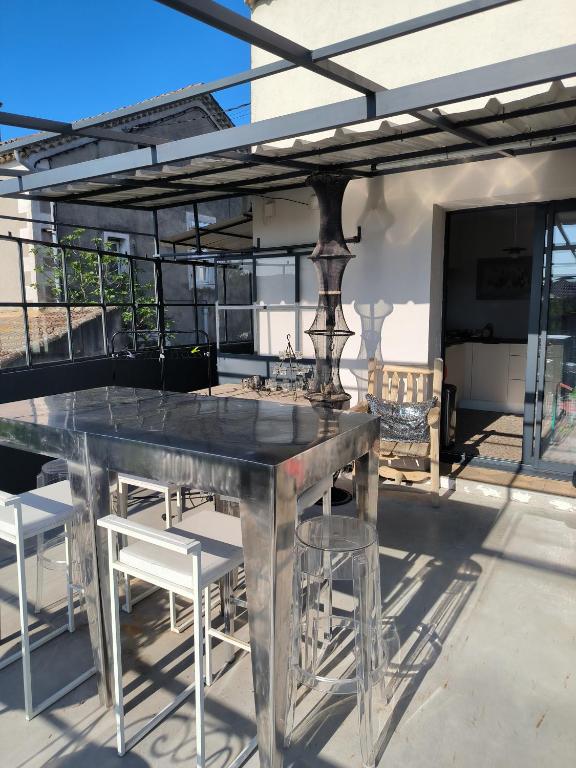 une table en métal et des chaises sur la terrasse dans l'établissement Charmant lavilledieu, à La Celle-sous-Gouzon