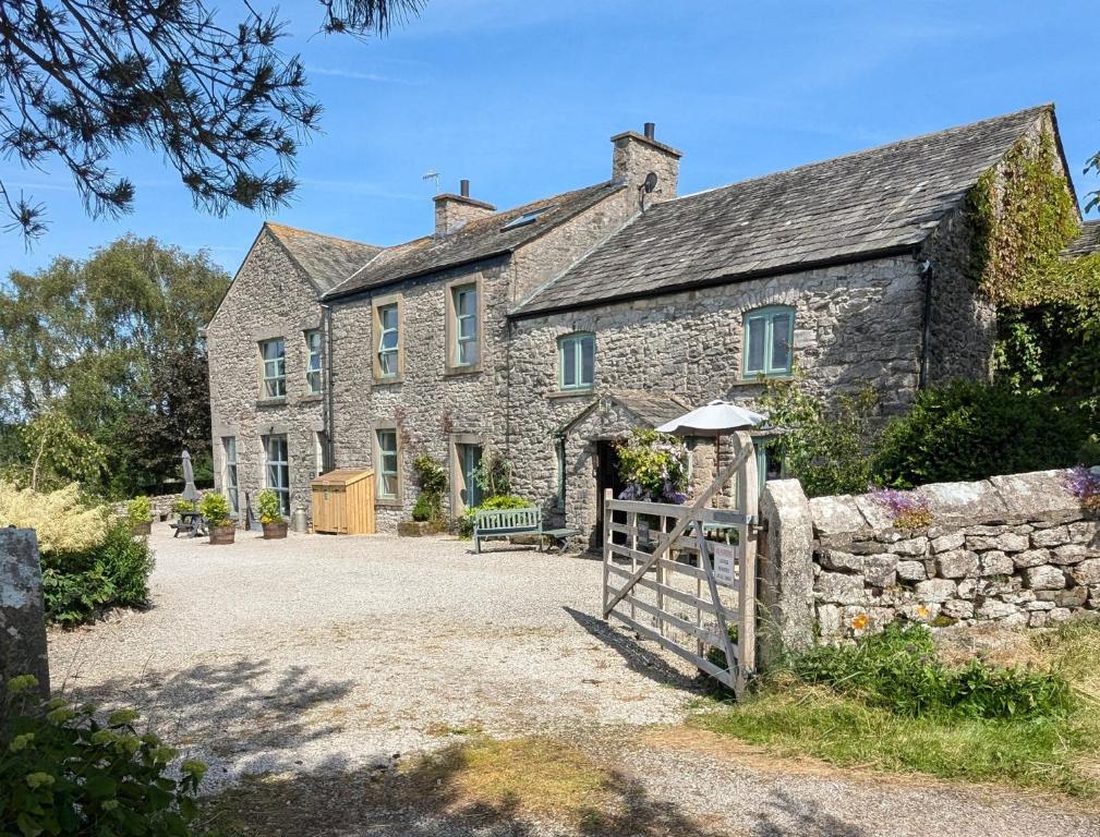an old stone house with a gate in front of it at The Dairy at Brackenthwaite Farm in Carnforth