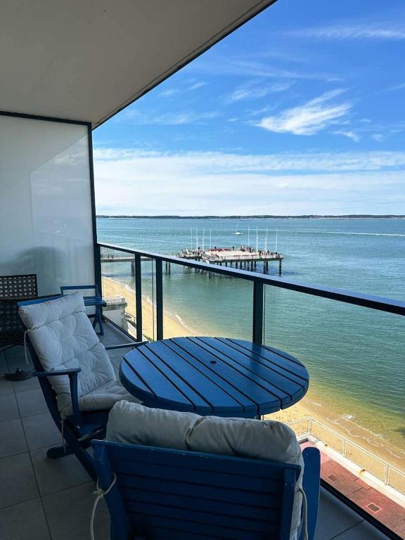d'un balcon avec des chaises et une table offrant une vue sur l'océan. dans l'établissement Résidence Les Goëlands - T1 vue mer, emplacement idéal près du centre MAE-9474, à Arcachon