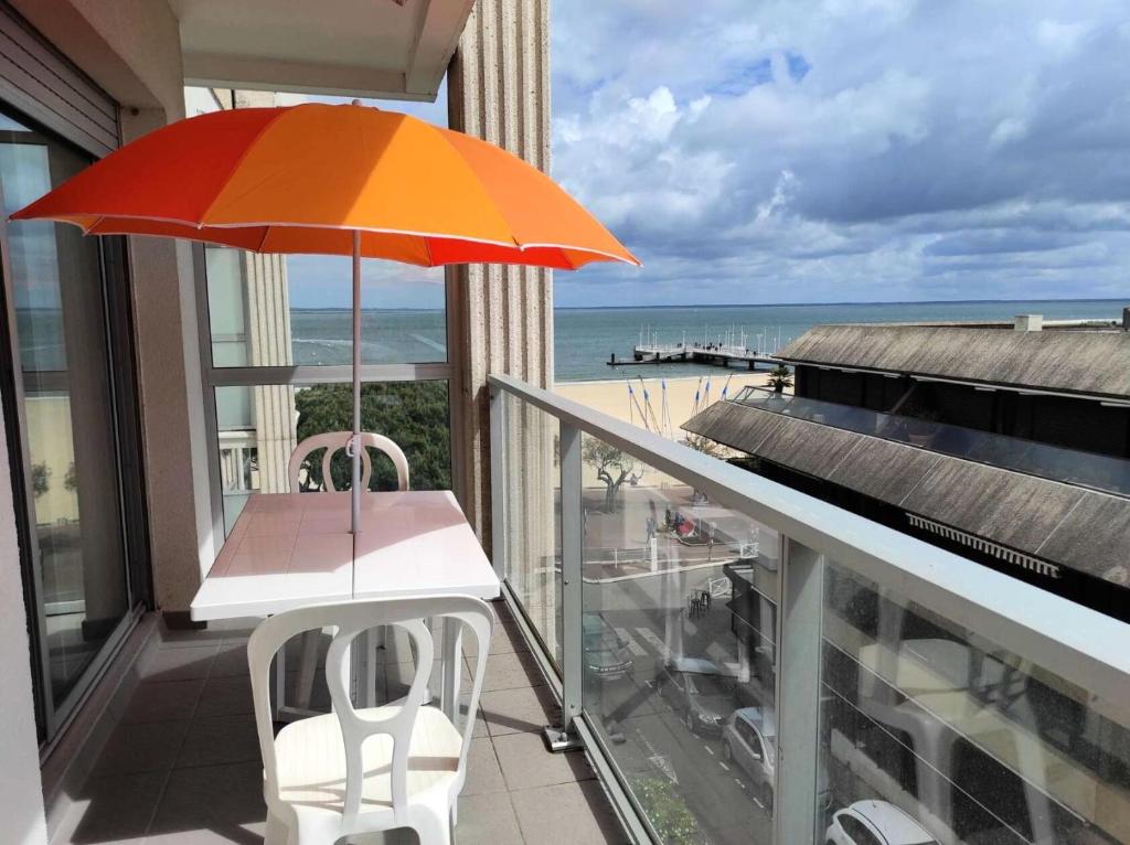 d'un balcon avec une table et un parasol donnant sur l'océan. dans l'établissement Résidence Claire - Arcachon – T2 en Plein Centre-Ville MAE-5414, à Arcachon