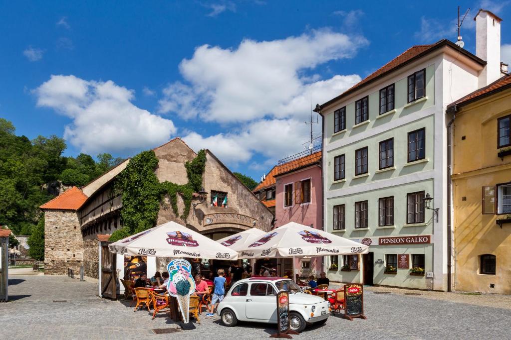 a group of umbrellas and a car in a street at Apartments Kajovska 63 in Český Krumlov