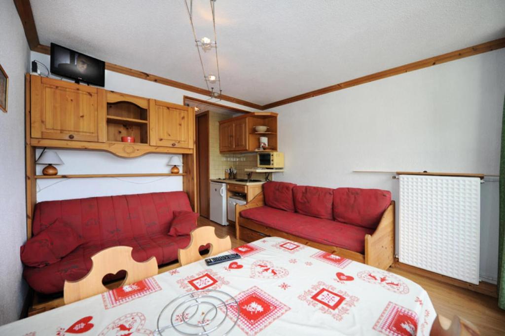 un salon avec un canapé rouge et une table dans l'établissement Résidence Chaviere - Studio agréable · Au pied des pistes · Balcon MAE-2754, aux Menuires