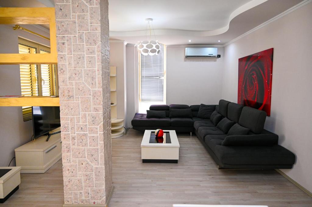 a living room with black couches and a tv at Dream House Apartment in Durrës