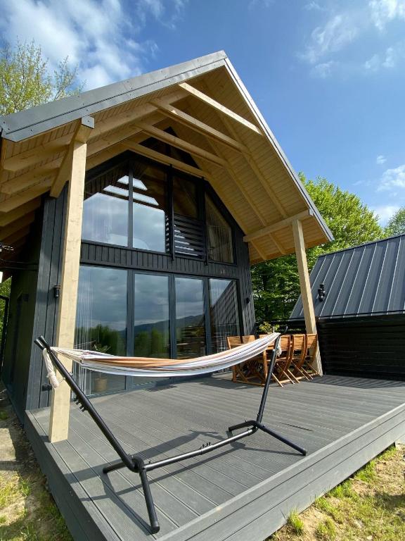 a house with a hammock in front of it at elements - Solina, z sauną in Solina