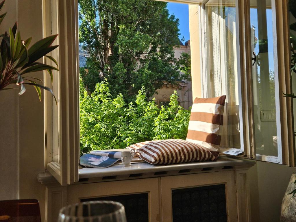 un siège côté fenêtre avec un oreiller et une vue sur la fenêtre dans l'établissement Design Old Town Aprt - Blue Church & Park - AC, à Bratislava