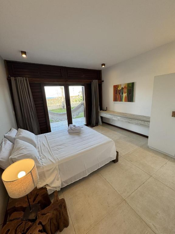 a bedroom with a large bed and a window at App Queen Kite Village in Uruau