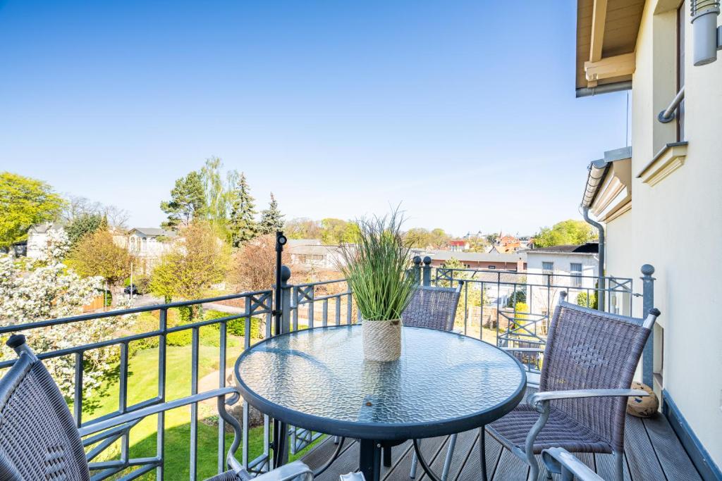 a patio with a table and chairs on a balcony at Villa Concordia Zinnowitz Ferienwohnungen nahe Strand mit großem Garten in Zinnowitz