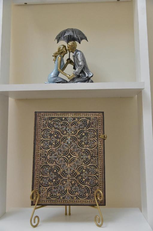 ein Regal mit einer Statue eines Mannes und einer Frau unter einem Regenschirm in der Unterkunft BLISS HOUSE center in Oradea