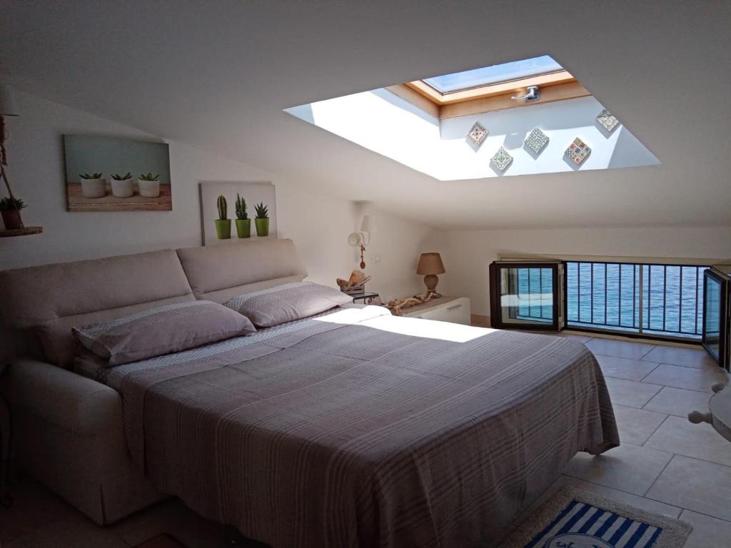 a bedroom with a large bed with a skylight at Villa Bella Sera in Scilla