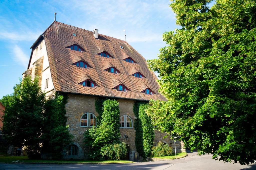 a white house with a blue roof and some trees at Jugendherberge Youth Hostel Rothenburg Ob Der Tauber in Rothenburg ob der Tauber