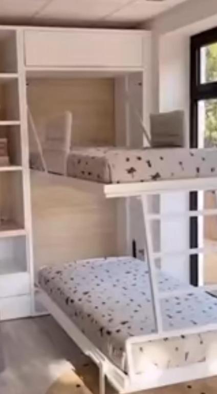 Cette chambre comprend des lits superposés et une étagère. dans l'établissement location villa cote, à La Celle-sous-Gouzon