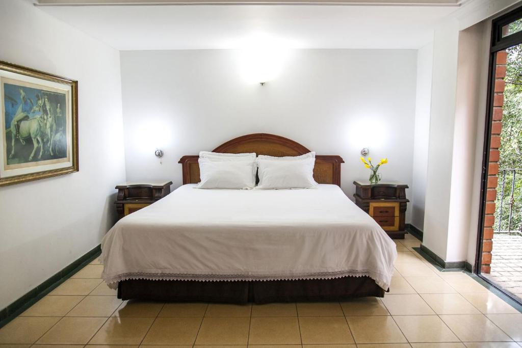 Postel nebo postele na pokoji v ubytování Hotel Casa Laureles