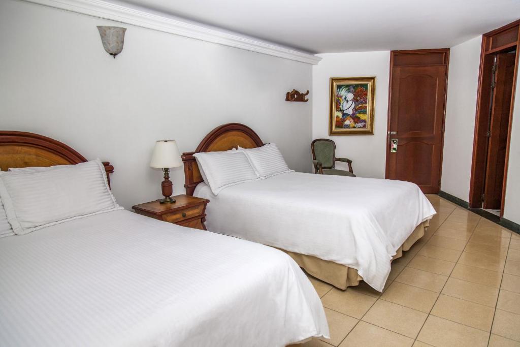 Postel nebo postele na pokoji v ubytování Hotel Casa Laureles