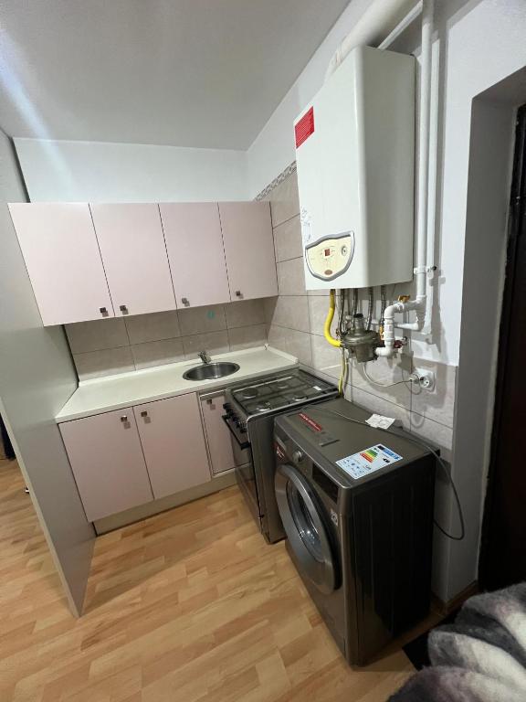 a small kitchen with a stove and a washing machine at Studio Chic in Bucharest