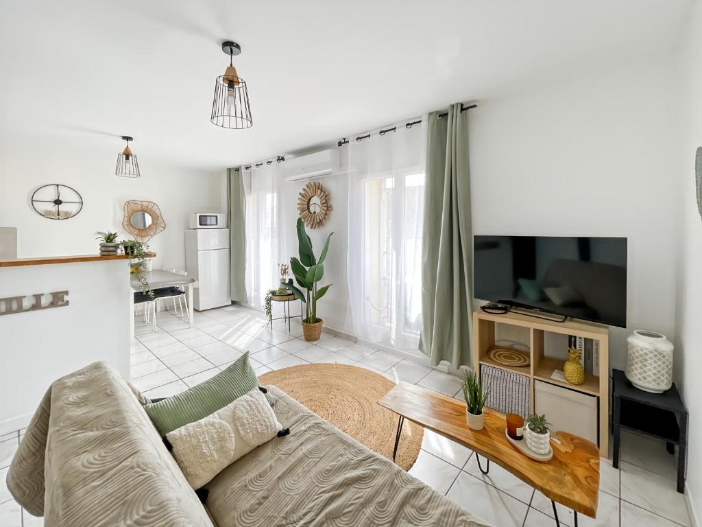 un salon avec un canapé et une télévision dans l'établissement St Martial Sète centre, CLIM, à Sète