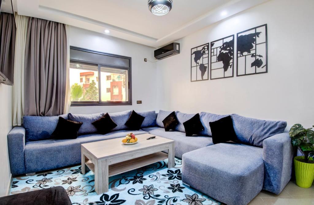 Una sala de estar con un sofá azul y una mesa. en Tranquil Retreat Amidst in Agadir, en Agadir