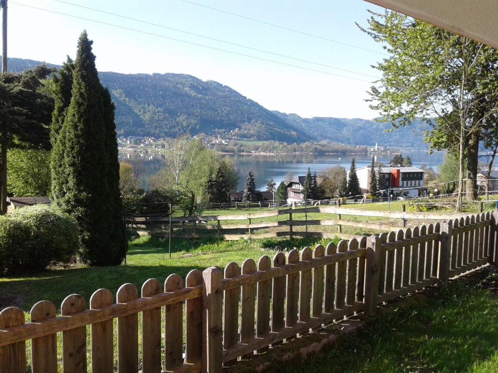 a wooden fence with a view of a lake at Ferienwohnung Angela in Steindorf am Ossiacher See
