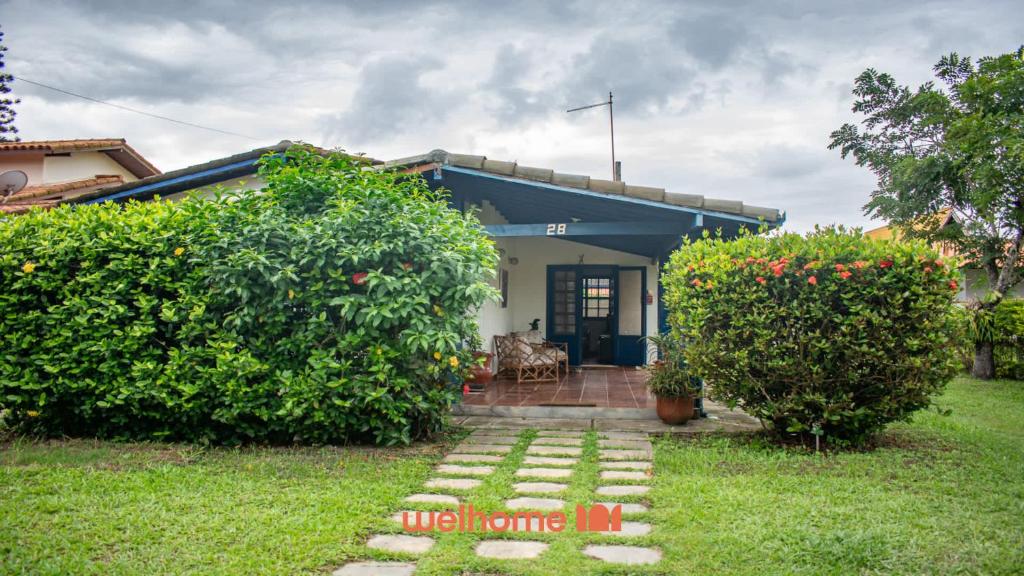 a house with a stone pathway in front of a yard at Casa em Cabo Frio com acesso direto à praia in Cabo Frio