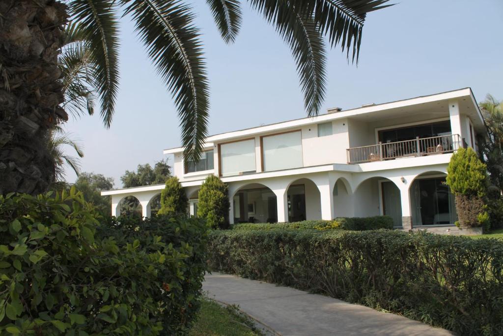 Casa Blanca HaciendaCasa de Campo 15 people with a pool的一座大型白色建筑,拥有棕榈树