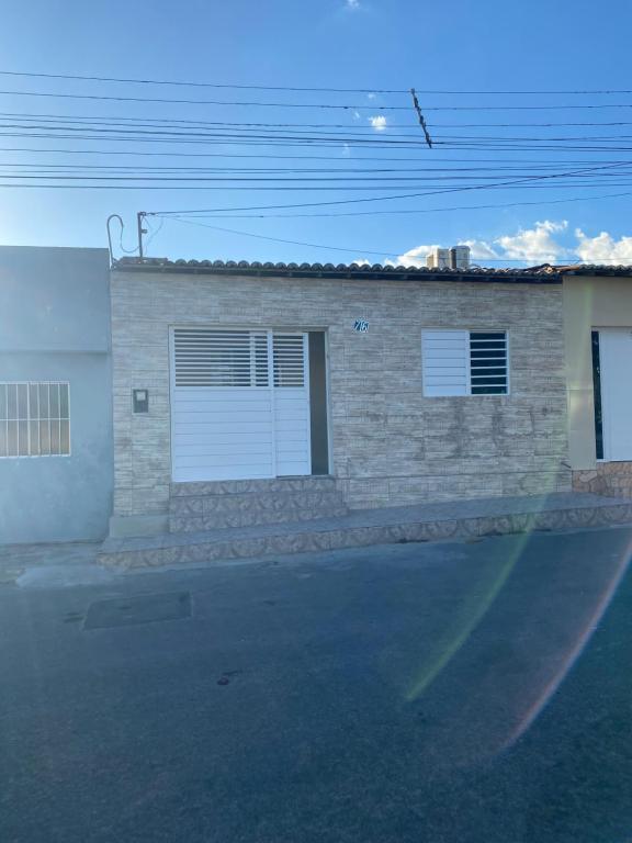 een stenen huis met twee garagedeuren in een straat bij Casa Aconchegante Odc in Olho D’Água do Casado