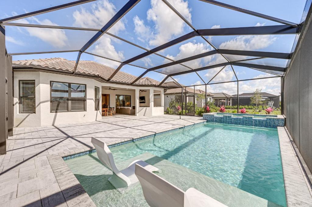 a swimming pool in a house with a glass ceiling at Golf, Swim, Shop and More Luxury Retreat in Naples! in Naples