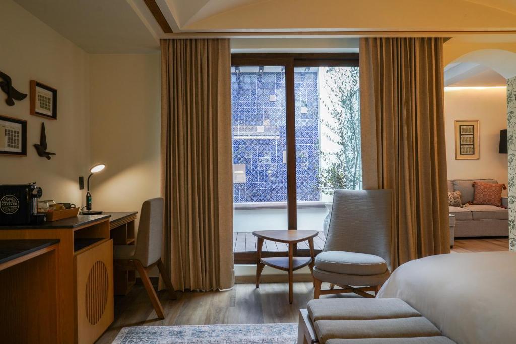 a hotel room with a bed and a desk and a window at Casa Postal Hotel Boutique in Querétaro