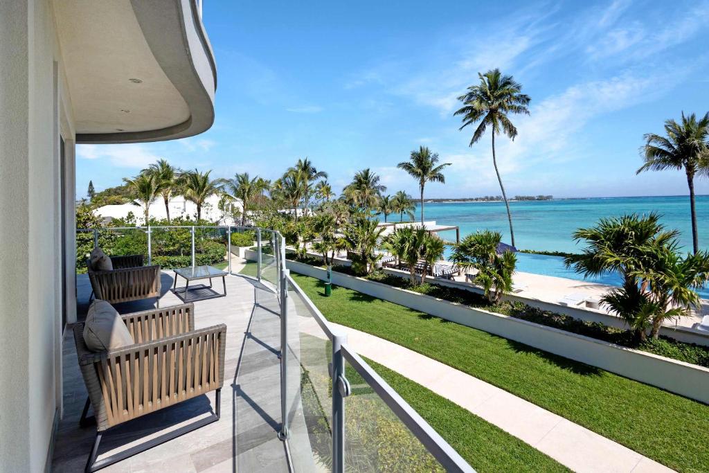 a balcony with a view of the ocean and palm trees at Cable Beach condo with ocean views in Nassau