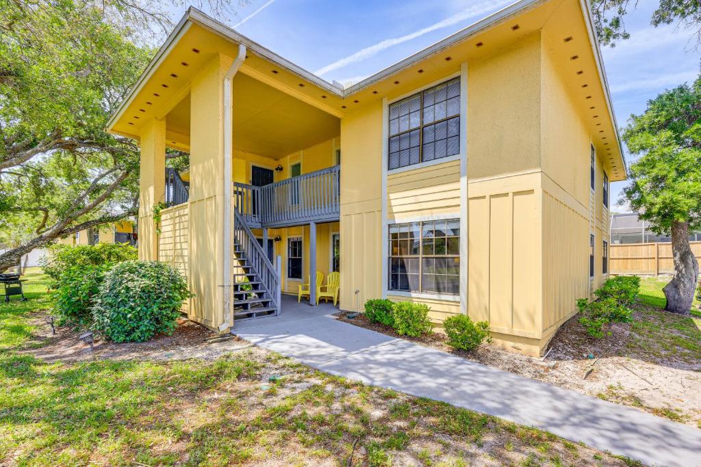 a large yellow building with a staircase in front at Walk to St Augustine Beach! Condo with Pool Access in Saint Augustine Beach