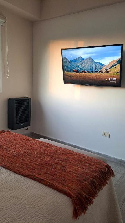 a bedroom with a flat screen tv on the wall at Chill Depto en Zona Centro in Chascomús