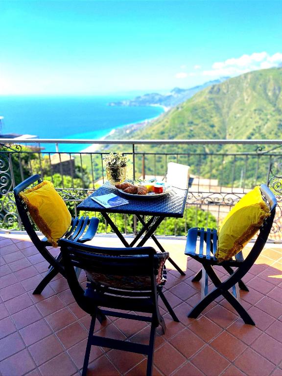 a table and chairs on a balcony with a view of the ocean at Casa Francesco in Forza dʼAgro