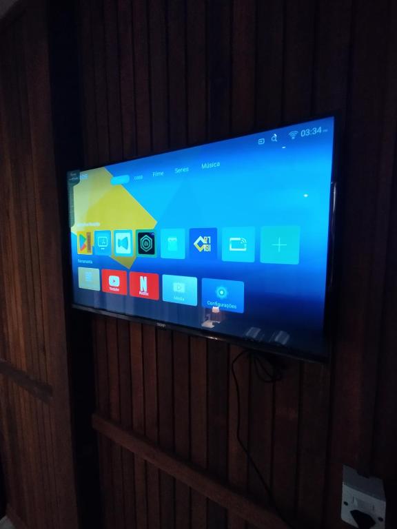 TV de pantalla plana en la pared en Casa balneário rincão sc, en Balneário do Rincão