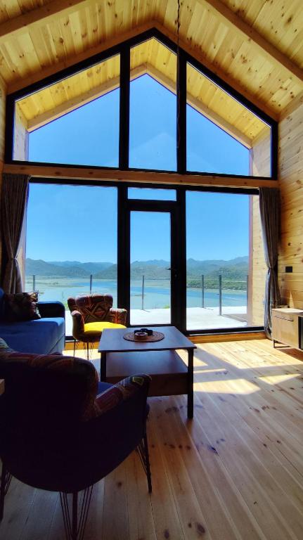 a living room with a large window with a view of the ocean at Above the Lake in Rogani