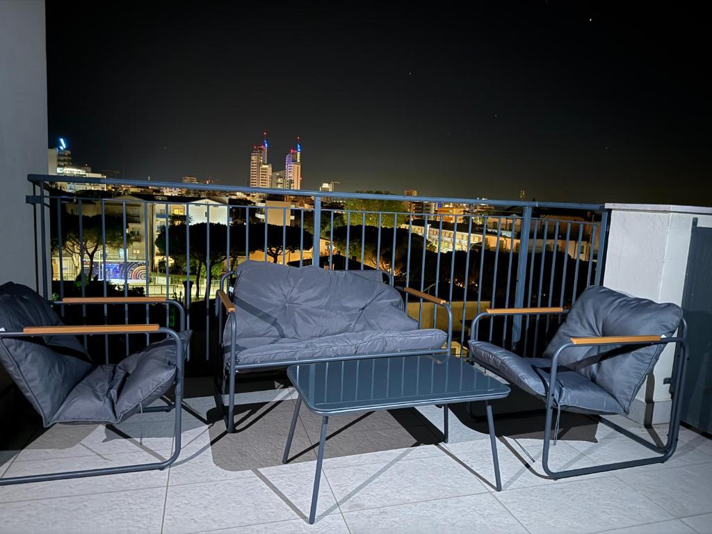 a balcony with two chairs and a table and chairs at Jesolo attic - beach spot in Lido di Jesolo