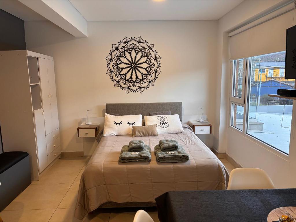 Un dormitorio con una cama grande con una ventana grande. en Departamento Austral II, en Ushuaia