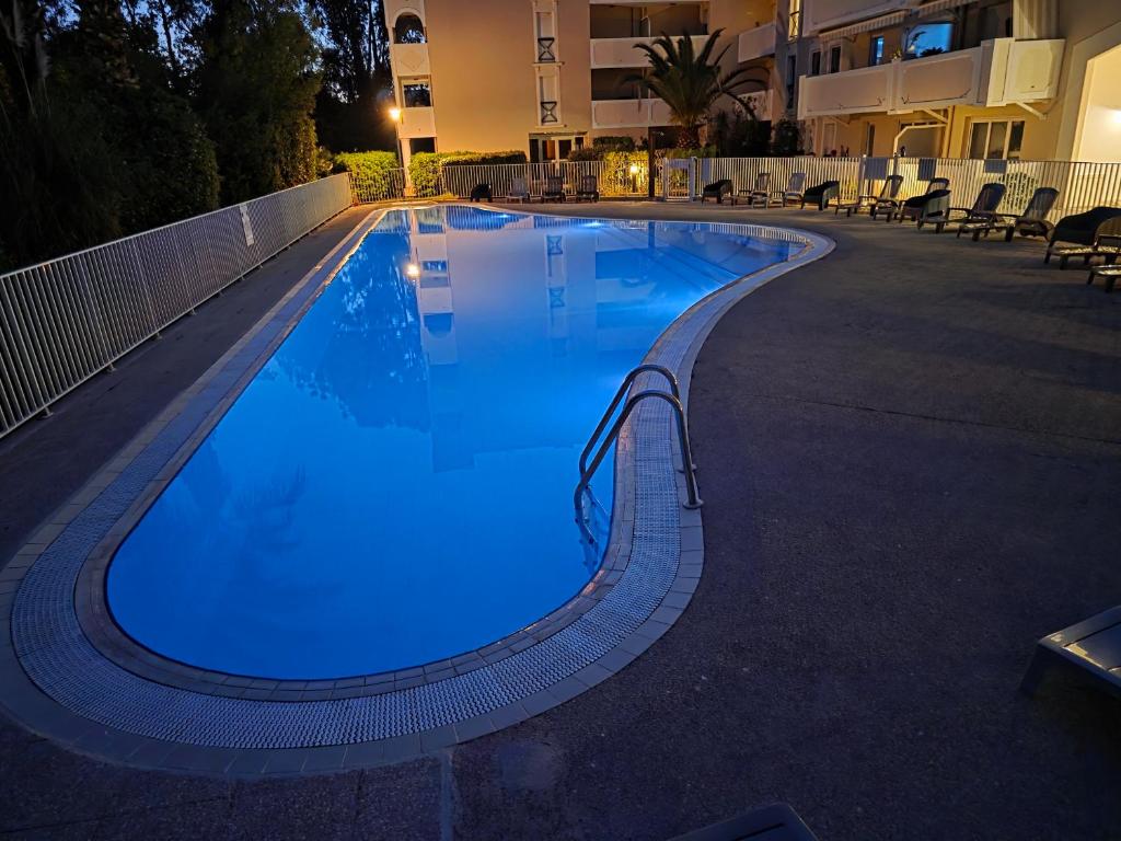 une piscine la nuit avec un éclairage bleu dans l'établissement Le Victoria-Centre ville-Piscine-Parking privé-Wi-Fi, à Hyères