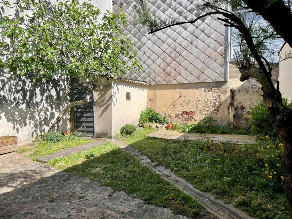 un jardin avec un bâtiment sur le toit dans l'établissement Maison 2 Chambres aux Sables-d'Olonne, à 100m de la Plage et du Marché Arago - FR-1-197-586, à Les Sables-dʼOlonne