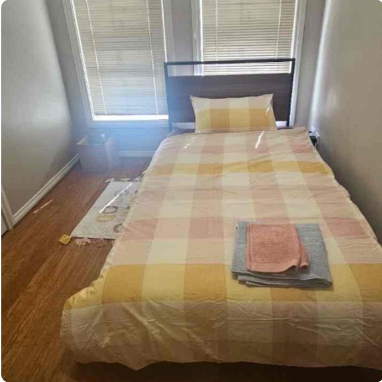 a bedroom with a bed with a checkered blanket at A Cosy Corner in Melbourne