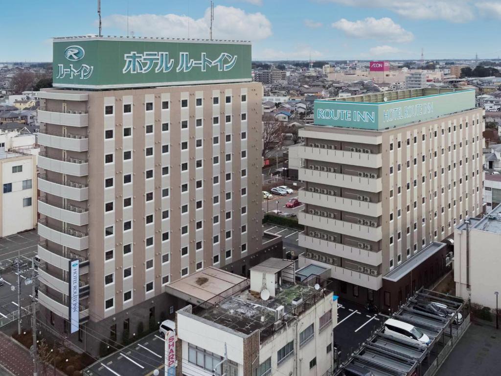 a large building with a sign on top of it at Hotel Route-Inn Koga Ekimae in Koga