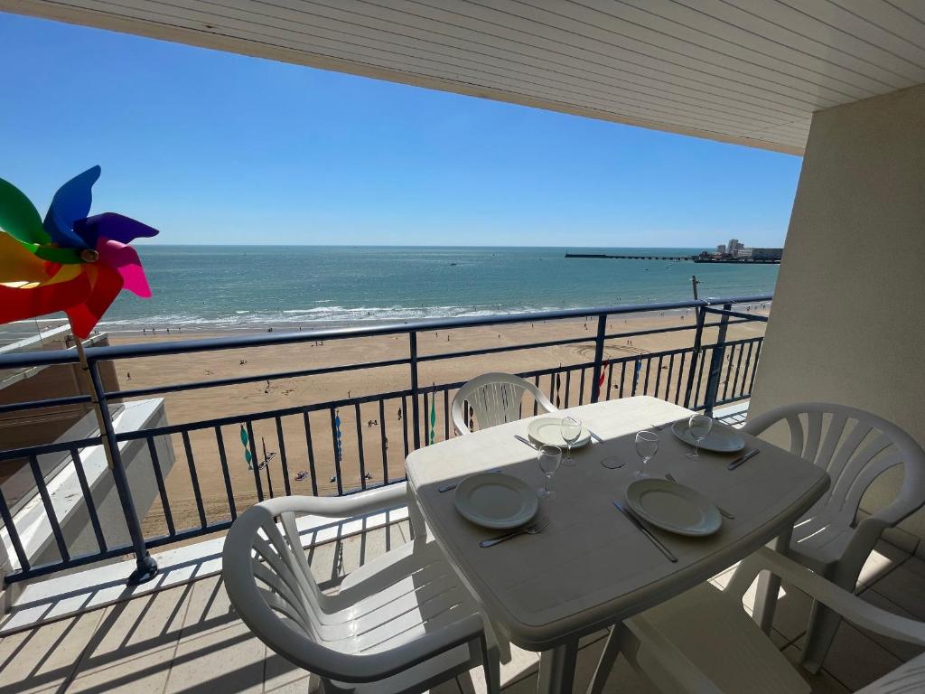 une table et des chaises sur un balcon avec vue sur l'océan dans l'établissement Face Océan : T3 au 9ème avec Balcon-Terrasse, Centre Plage et Ville, Tout Confort - FR-1-92-645, à Les Sables-dʼOlonne