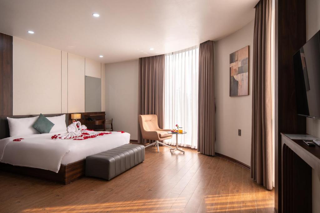 una habitación de hotel con una cama y una silla en Eden Hue Hotel, en Hue