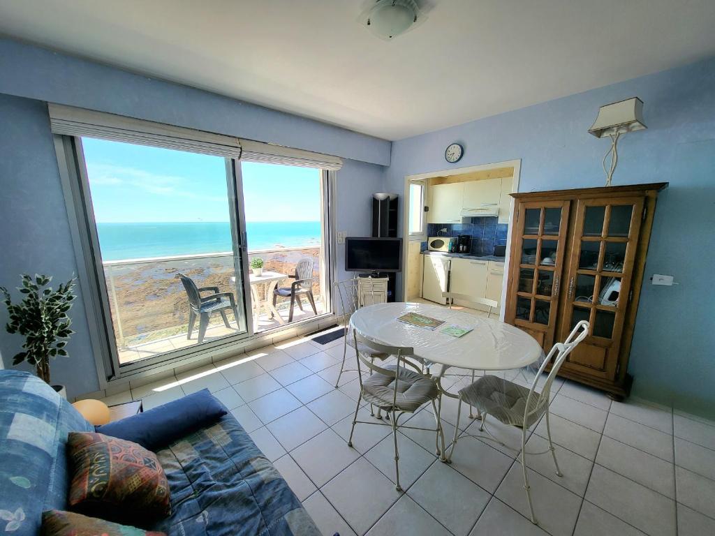 - un salon avec une table et une vue sur l'océan dans l'établissement Charmant studio avec balcon, animaux acceptés, parking privé, proche plage et commerces - FR-1-92-915, à Les Sables-dʼOlonne