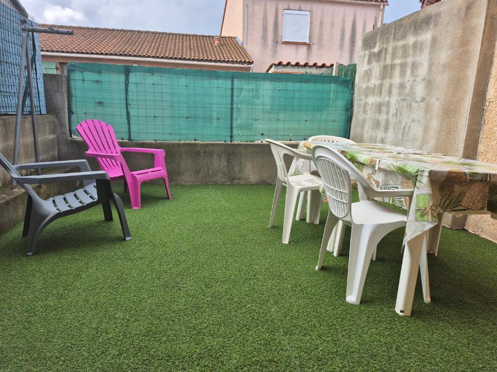 un groupe de chaises et de tables sur une terrasse dans l'établissement Maison Climatisée 4 Pers, Parking, Argelès-sur-Mer - FR-1-776-136, à Argelès-sur-Mer