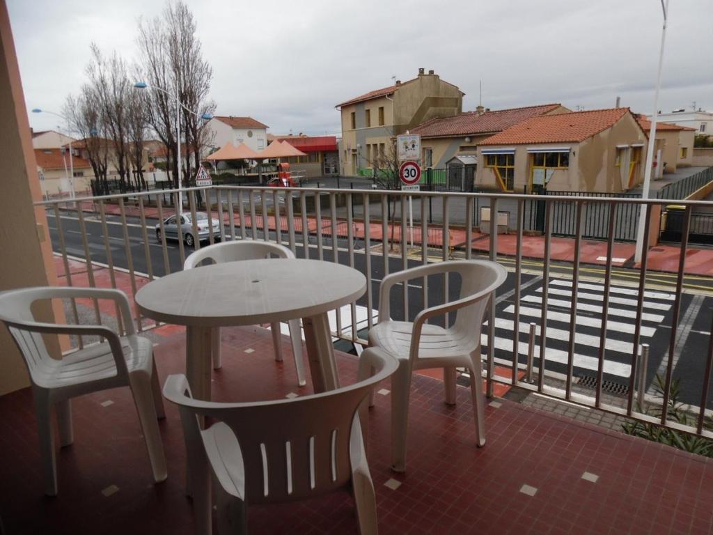 une table et des chaises assises au-dessus d'un balcon dans l'établissement Deux-pièces 4 pers avec parking, proche plage - FR-1-750-89, à Canet