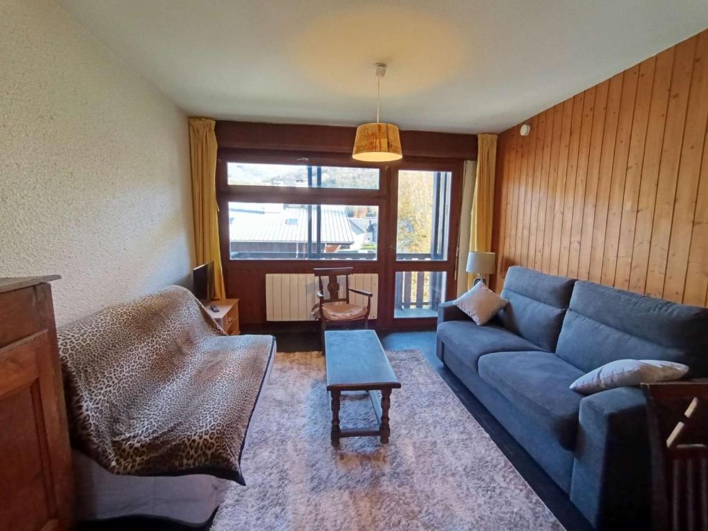un salon avec un canapé bleu et une table dans l'établissement Appart T2 pour 6 pers. à Saint-Lary-Soulan - FR-1-457-381, à Saint-Lary-Soulan