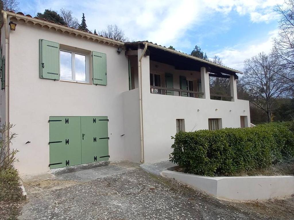 une maison blanche avec des portes vertes et une haie dans l'établissement Villa provençale avec jardin et parking pour 4 personnes près du centre de Riez - FR-1-822-17, à Riez