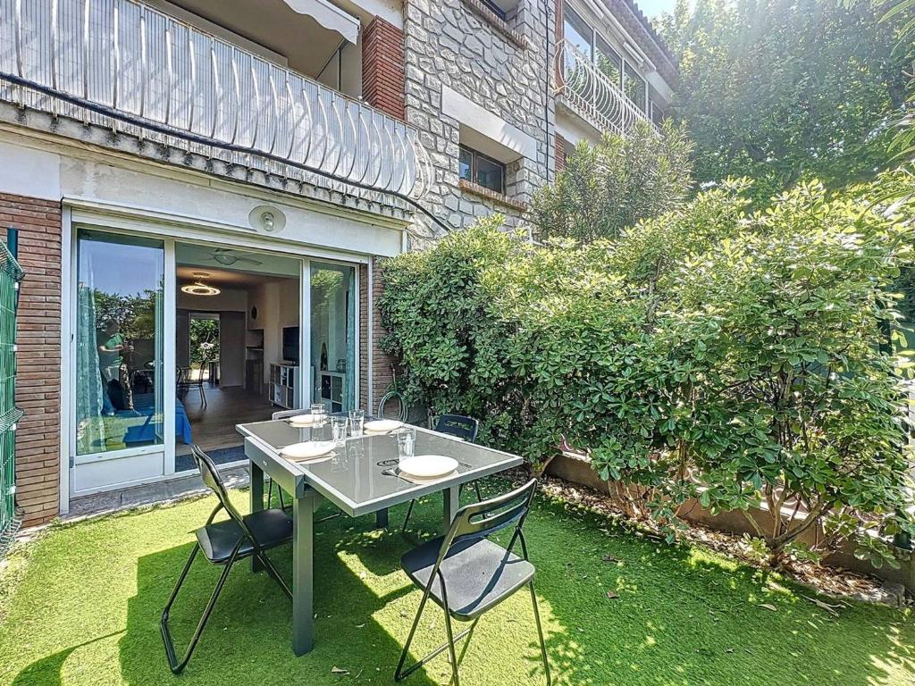 un patio avec une table et des chaises dans une cour dans l'établissement Charmant T2 refait à neuf avec jardin et parking à St Cyr sur Mer, proche plage - FR-1-770-48, à Saint-Cyr-sur-Mer