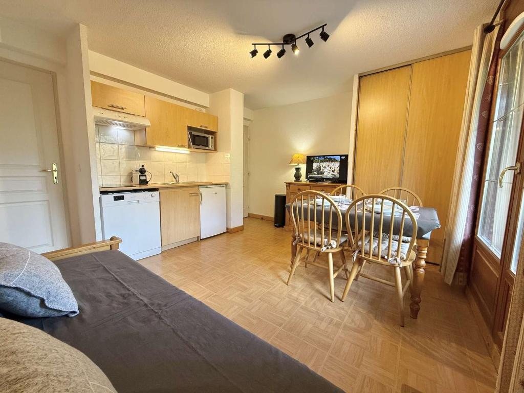 une pièce avec une table et des chaises et une cuisine dans l'établissement Appartement cosy à Flumet avec parking et piscine - FR-1-603-121, à Flumet