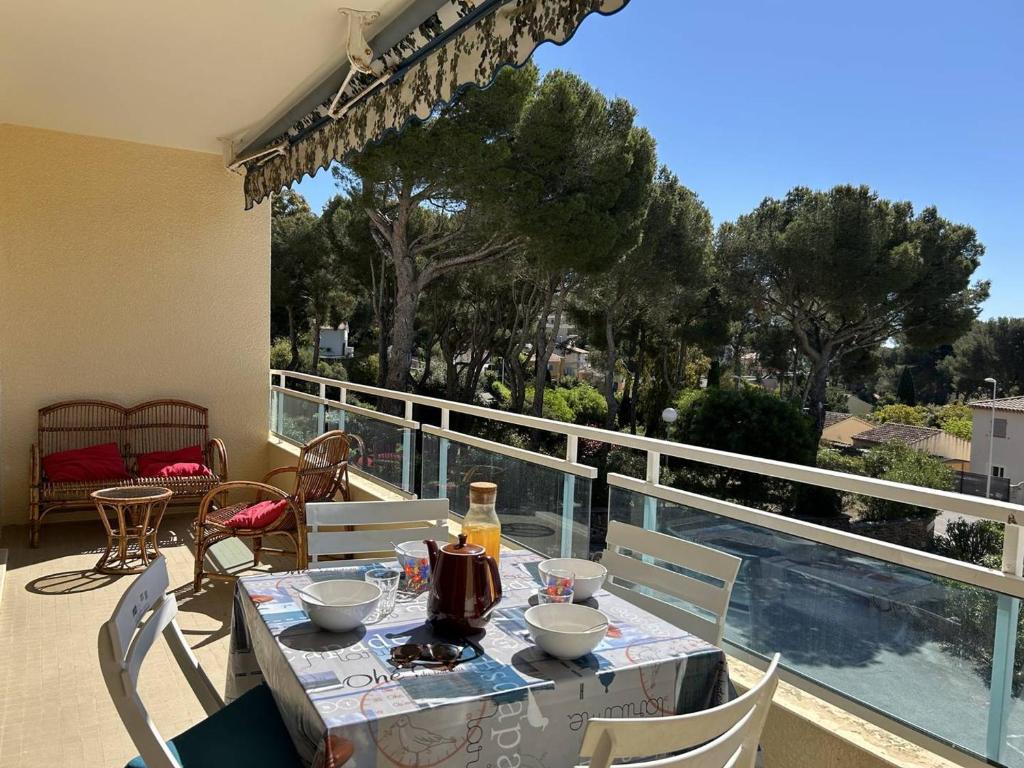 une table et des chaises sur le balcon d'une maison dans l'établissement Appartement 2P à Bormes-les-Mimosas avec accès piscine - FR-1-251-859, à Bormes-les-Mimosas